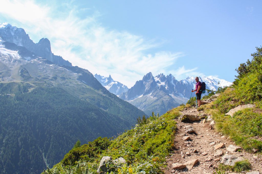 guy standing on a trail with mont blanc massif in the background