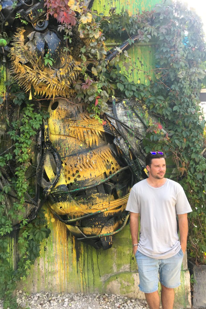 guy standing in front of LX factory wall art