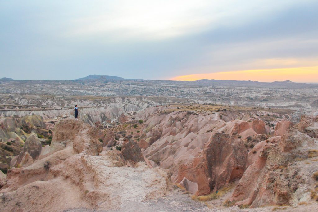 girl standing amongst cappadocia red valley